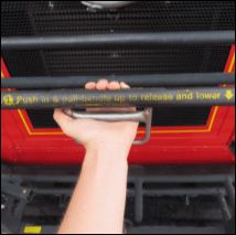 A hand, gripping and squeezing the handle of a bus bike rack to release and open it
