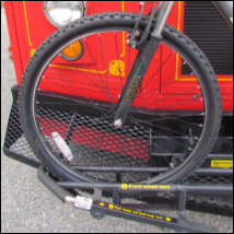 Left side of a bus bike rack with a bicycle placed in to show correct tire placement